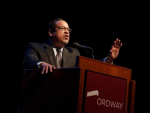 a man is speaking at a podium