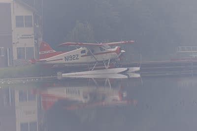 a float plane sits on a lake in smoky weather