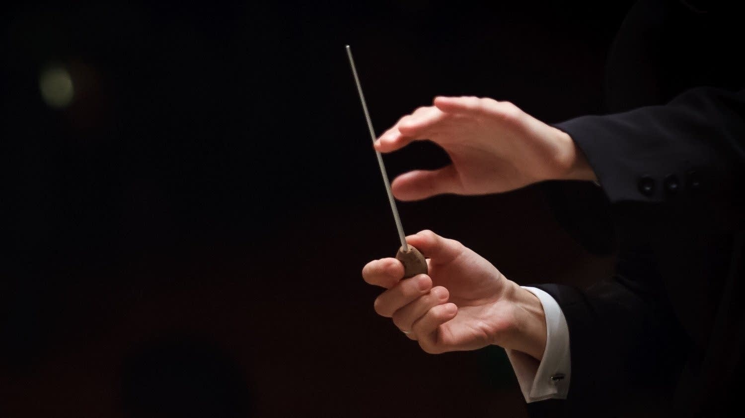 Why does the conductor use a baton?