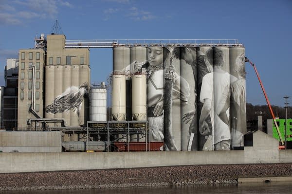 large silos painted with images of young children dancing