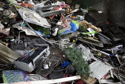 A pile of discarded electronics, cords and holiday decorations. 