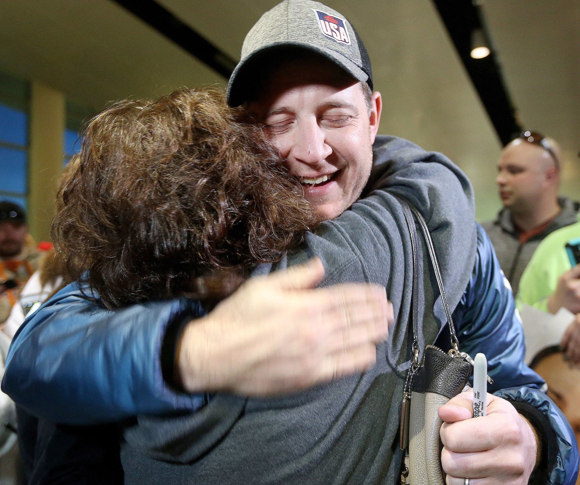 John Shuster of the Duluth curling team gets a big hug from Kim Hinz.