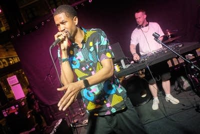 One musician raps while another DJs onstage