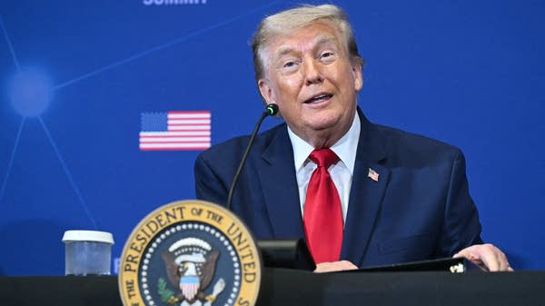 President Trump before a microphone.
