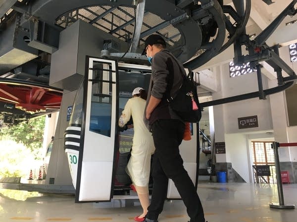 Cable car taking tourists up to the top of Mount Cangshan are supposed to be disinfected before and after each trip, although in practice it meant one spray of disinfectant on the floor before the next group of tourists hop in. (Jennifer Pak/Marketplace)