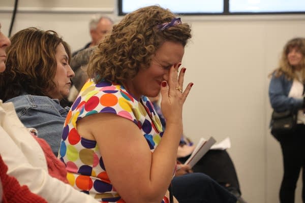 A woman makes a face and touches her hand