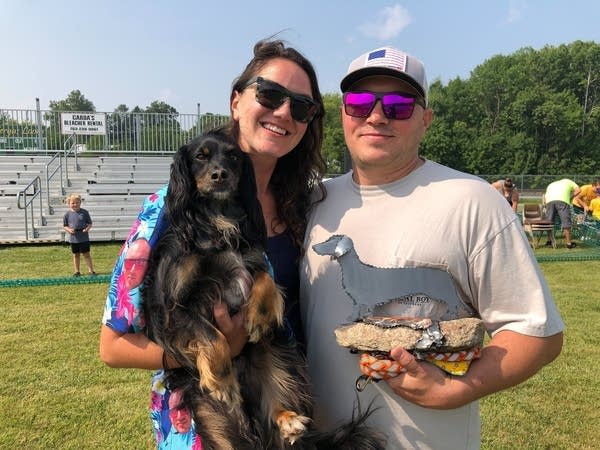 Two people pose with their dog