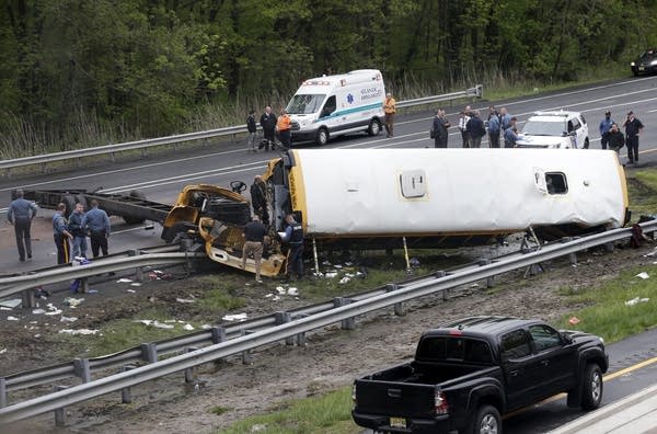 Emergency personnel work at the scene of a school bus, dump truck collision