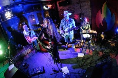 Five musicians performing onstage