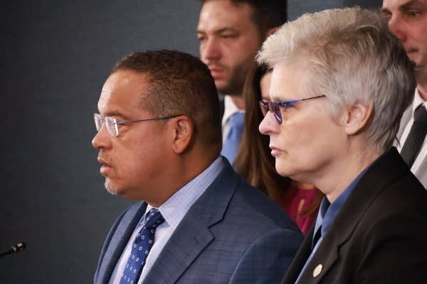 man and woman speak at news conference