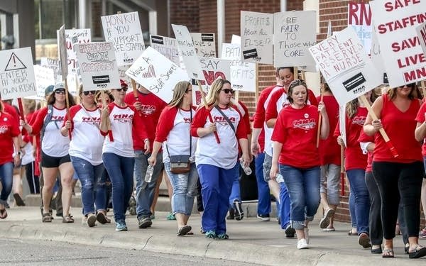 Marchers walk along a picket line