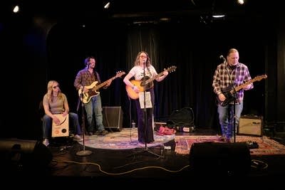 Four musicians performing onstage