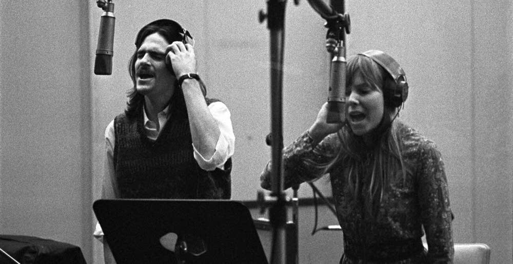 James Taylor and Joni Mitchell singing together in a recording studio
