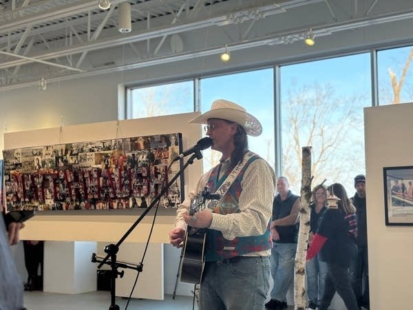 A person performs at an art reception 