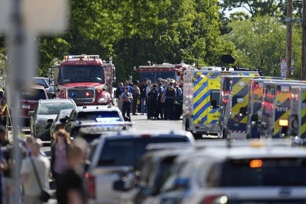 Emergency vehicles crowd a street