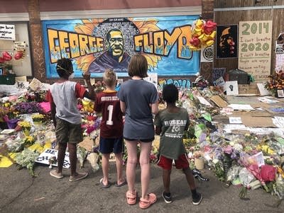 A transracial family looks at a mural at a memorial.