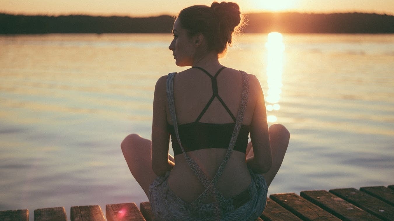 Woman on dock at sunset.