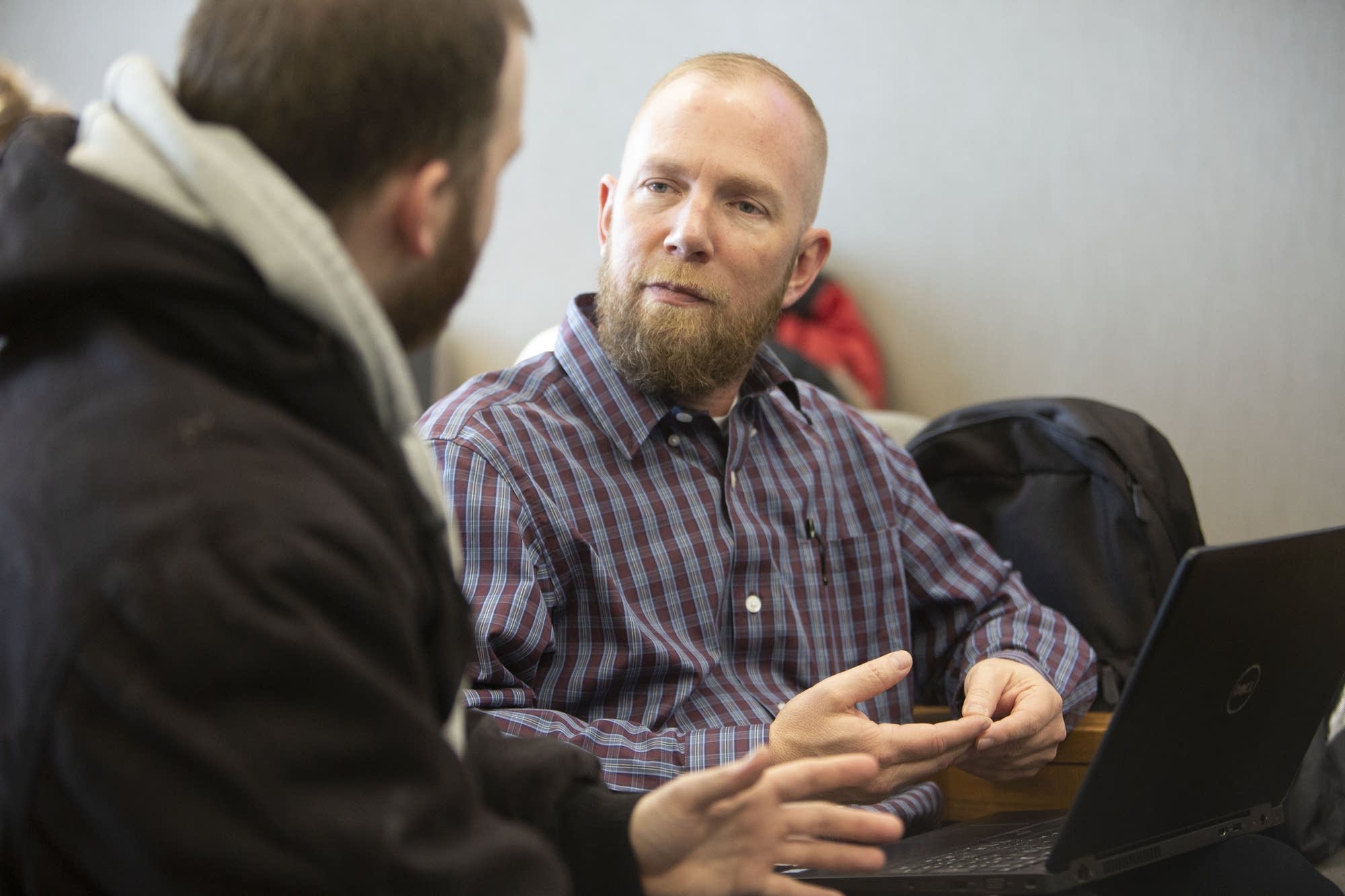 Certified financial counselor Chad Larimer (right) talks with Josh Stone.
