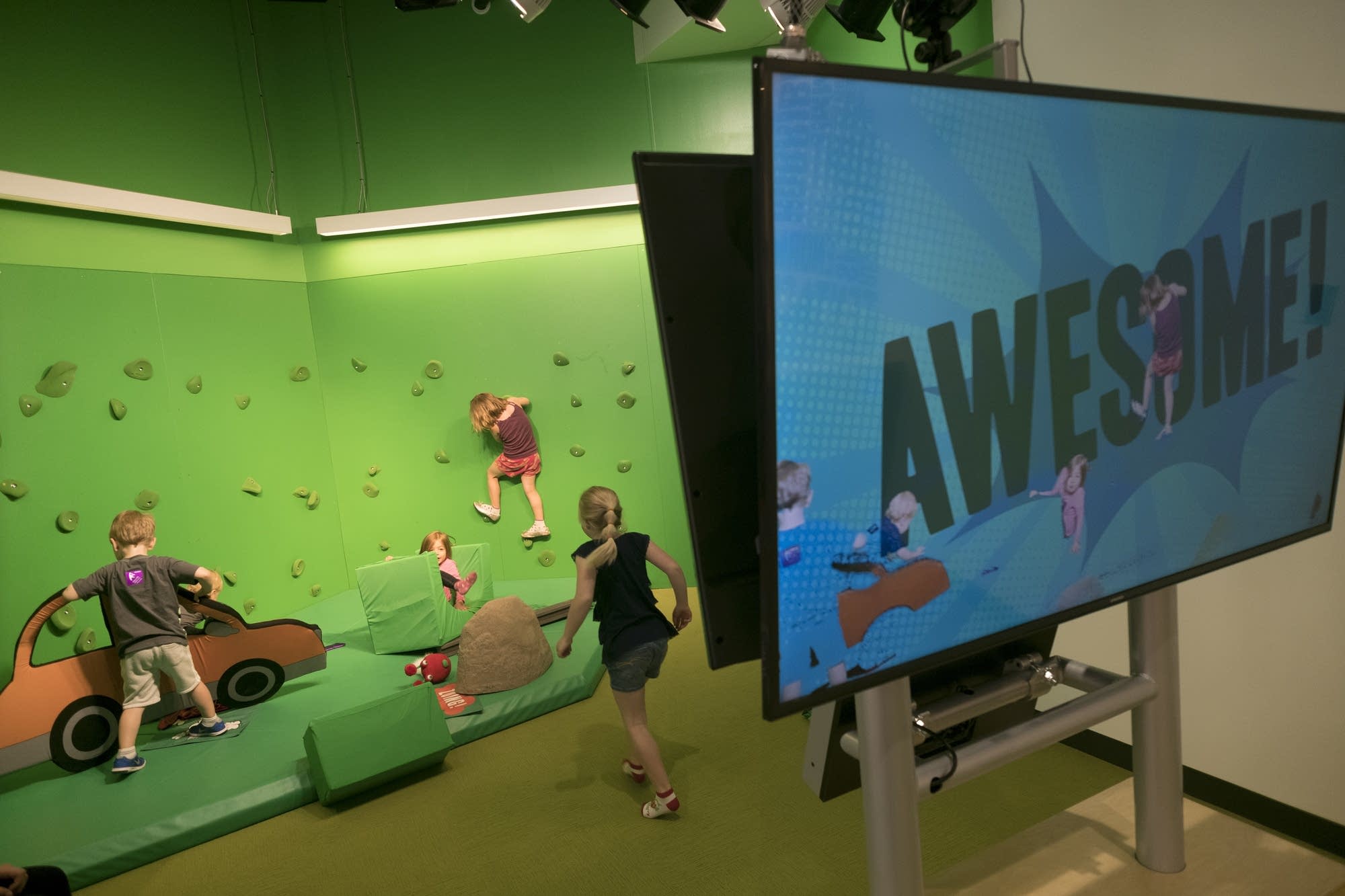 Kids climb on a green screen.