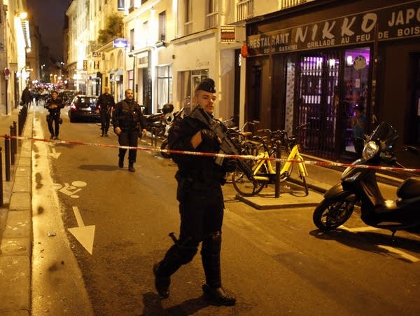 A police officer cordons off the area after a knife attack in Paris