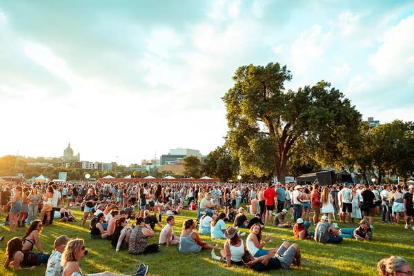 Music fans gathering on a vast park on a summer day