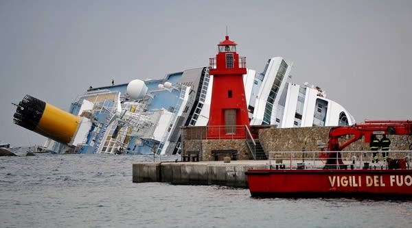 Firemen patrol near the Costa Concordia cruiseship on January 16, 2012 in the harbor of the Tuscan island of Giglio after it ran aground and keeled over off the Isola del Giglio after hitting underwater rocks on January 13.