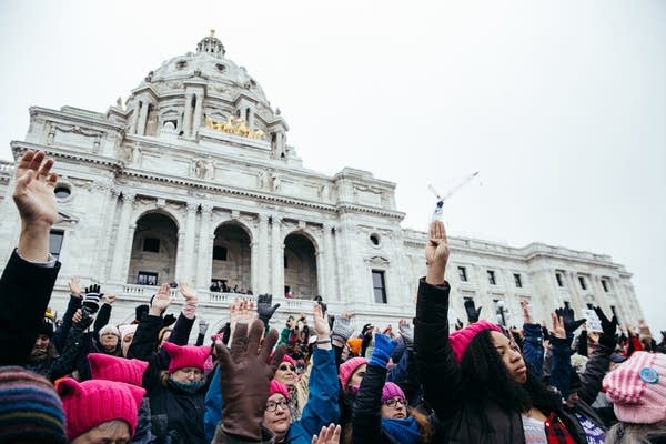 Demonstrators stand for a moment of silence.