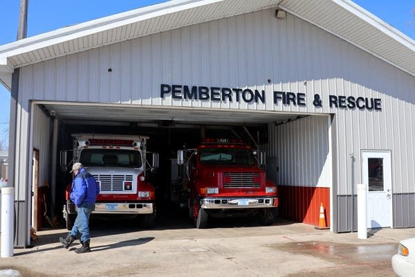 Two fire engines are parked in an open garage.