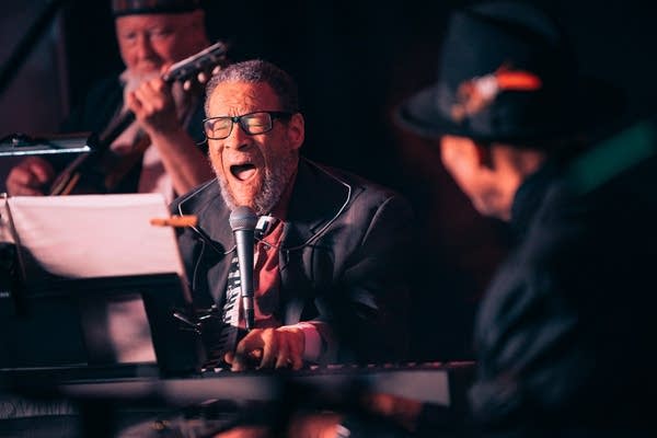 Cornbread Harris holds a note in "Cornbread" while Jimmy Jam smiles and looks on.