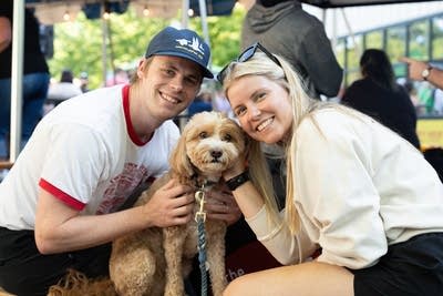 Two people posing with their dog.