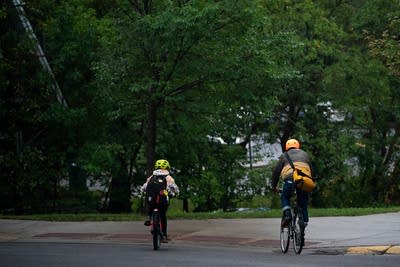 Two people ride bikes