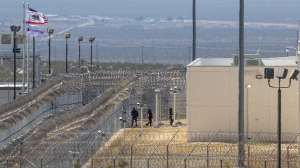 People enter the California City Immigration Processing Center.