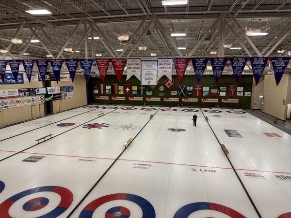 Championship banners hang above the ice at a curling club