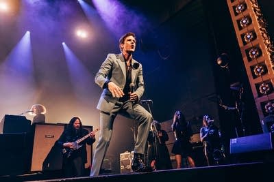 A band performing onstage in a large music venue