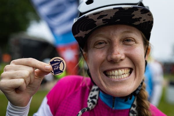 A woman holds up a wooden coin