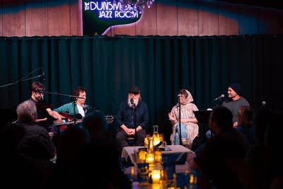 Lambchop performs seated on a stage.
