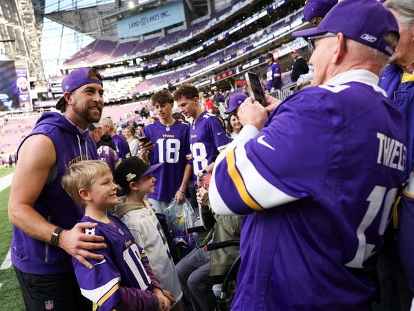 A football player greets fans before a game