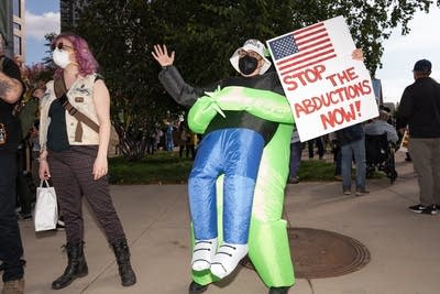 A man holds a sign that says stop the abductions now