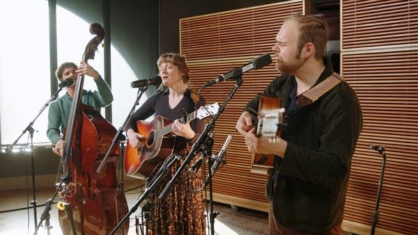 Three musicians performing together in a recording studio