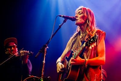 Two musicians performing together onstage in a music venue