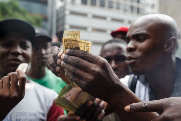 Public transport drivers pay for fuel in US dollars at a station in Harare, Zimbabwe. (Photo by JEKESAI NJIKIZANA/AFP/Getty Images)