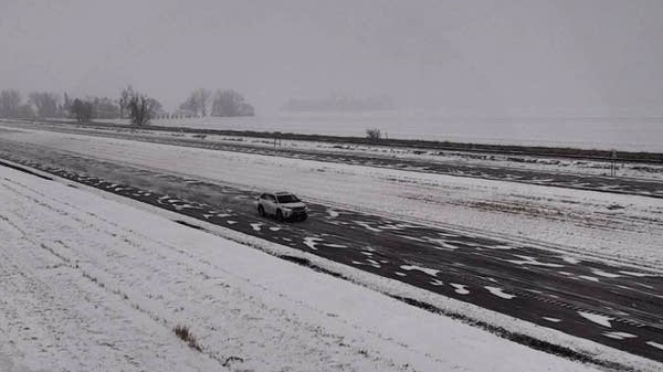 A car travels along a snowy highway