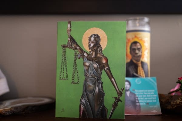 A postcard featuring a blindfolded lady justice