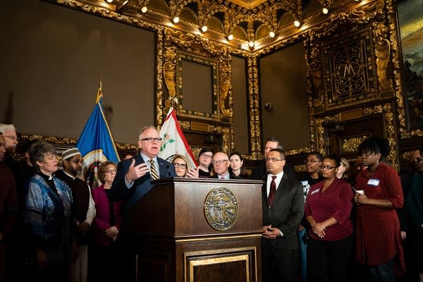 Tim Walz stands with educators, faith leaders and government officials.