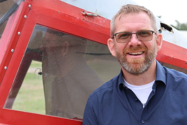 Darrin Smedsmo stands next to his airplane 