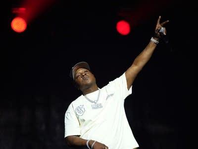 Jadakiss with arm up on stage