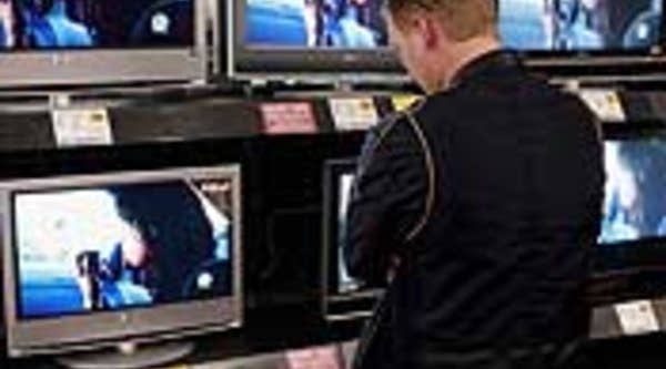 A customer looks over flat-panel televisions at a Best Buy store in Chicago, Ill.