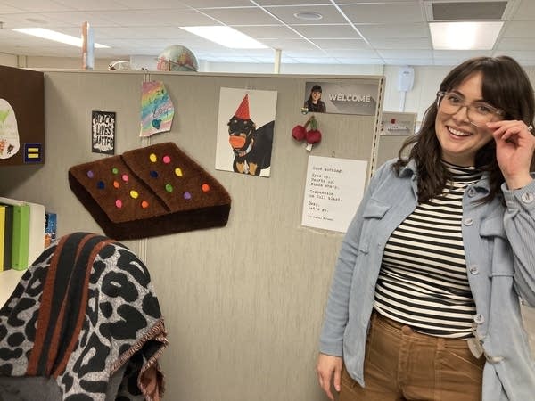 A woman stands at her desk