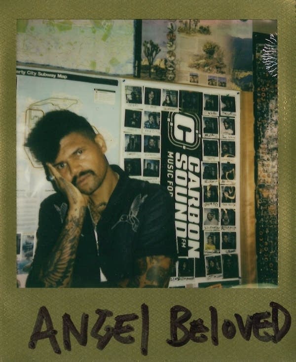 man poses for polaroid with face in his hand