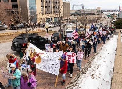 people march in a rally with signs